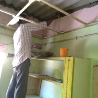 Ein Arbeiter beim abdichten des Daches zur Hauswand Ein Arbeiter beim abdichten des Daches zur Hauswand