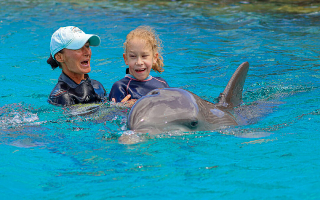 Sarah mit dem Delfin im Wasser